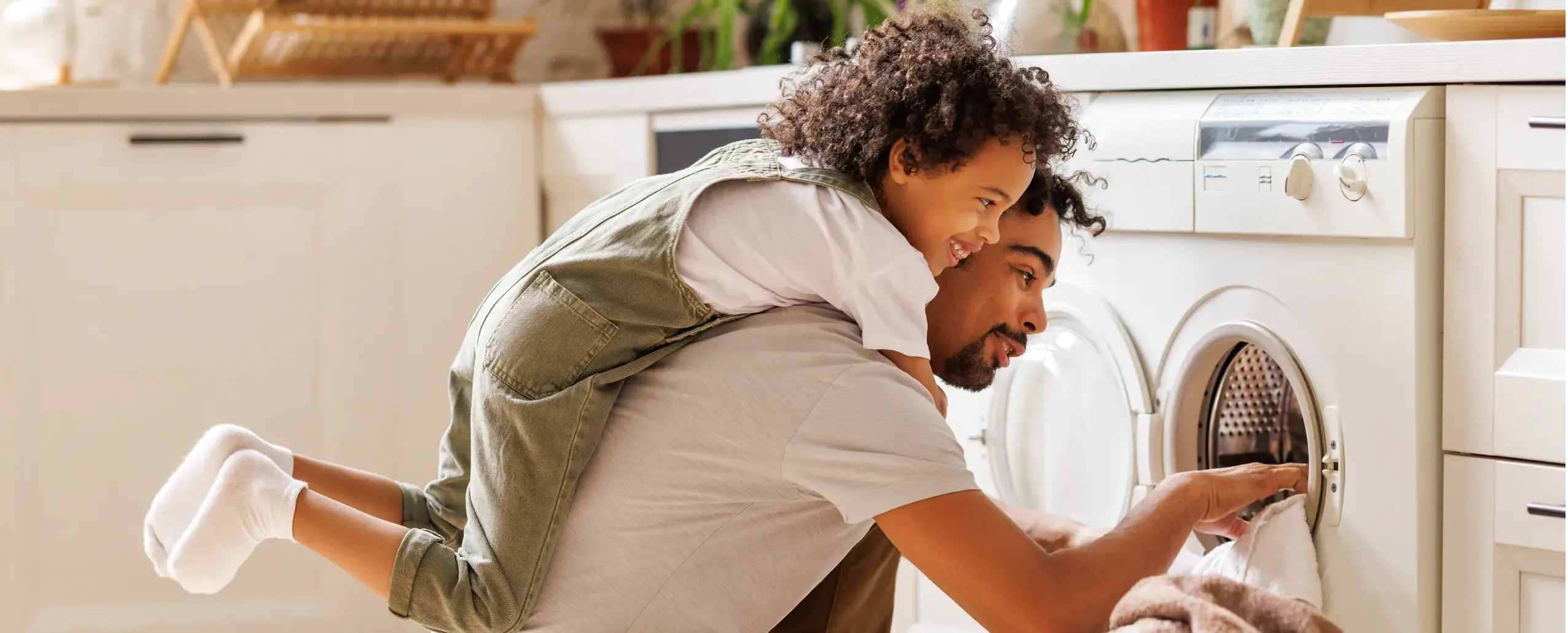Father and daughter putting clothes into an energy-saving washing machine